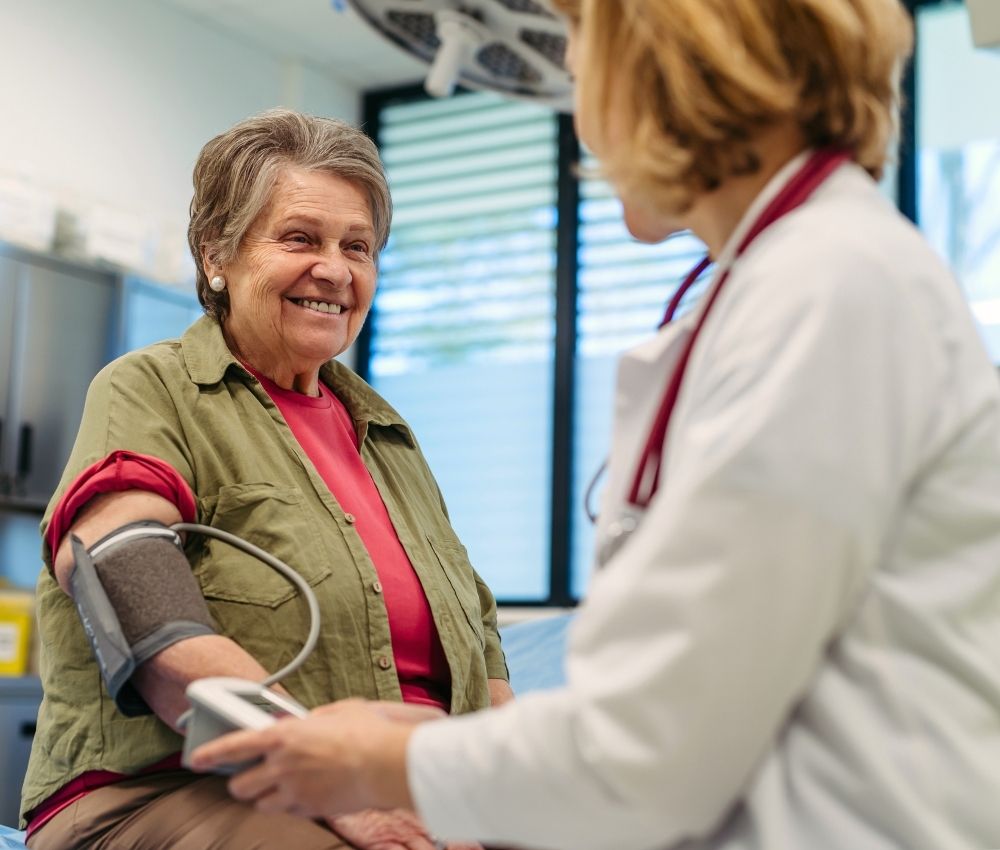 an obese senior is sitting for checkup with doctor